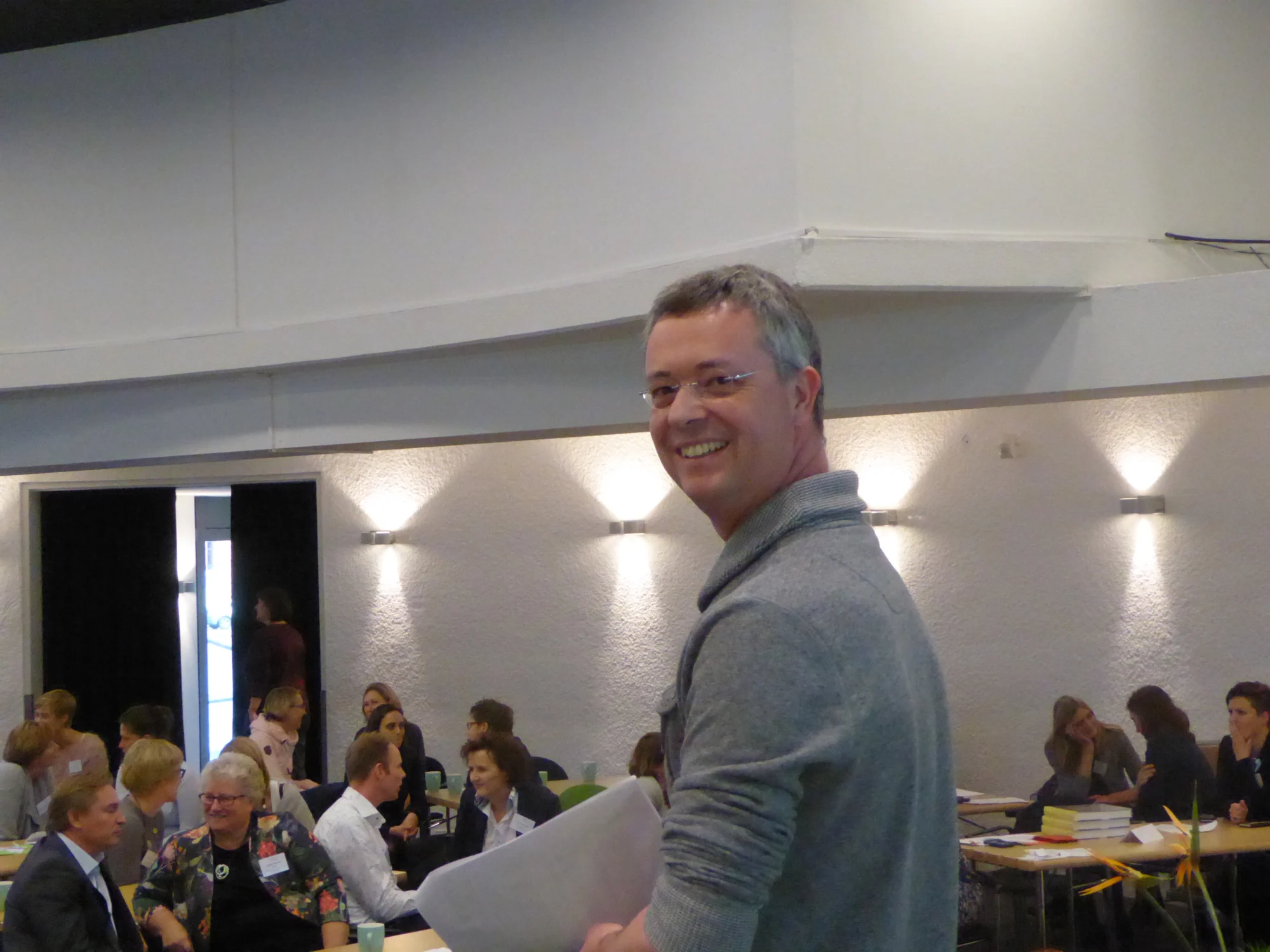 David Borman lachend voor een zaal met deelnemers